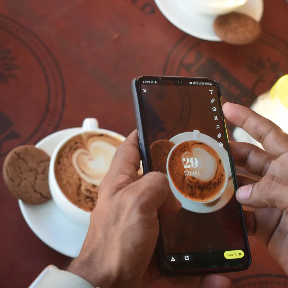 Posting an image of a cup of coffee on Instagram on a mobile phone
